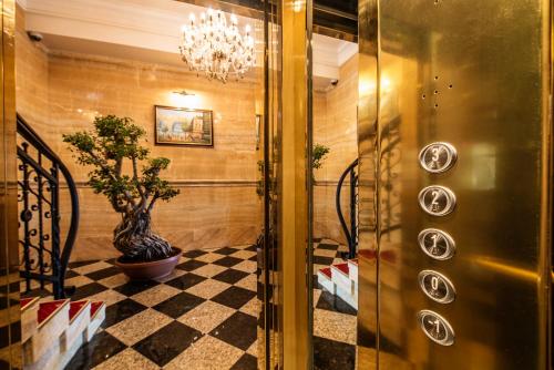 um corredor com um vaso de planta num piso xadrez em Hotel Europa em Poprad