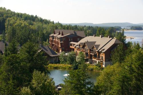 um grupo de casas numa colina ao lado de um lago em Les Condos Du Lac Taureau- Rooms & Condos em Saint-Michel-des-Saints