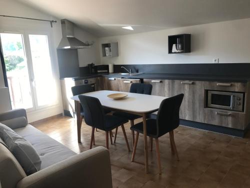 a kitchen and dining room with a table and chairs at Lavande 3ème étage in Le Mas