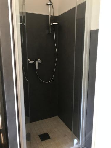 een douche met een glazen deur in de badkamer bij Lavande 3ème étage in Le Mas