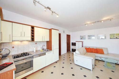 a kitchen with white cabinets and a couch in a room at Apartment Sapavac in Vir