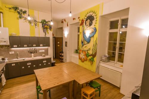 プラハにあるThe MadHouse Pragueのテーブル付きのキッチン、壁に絵画