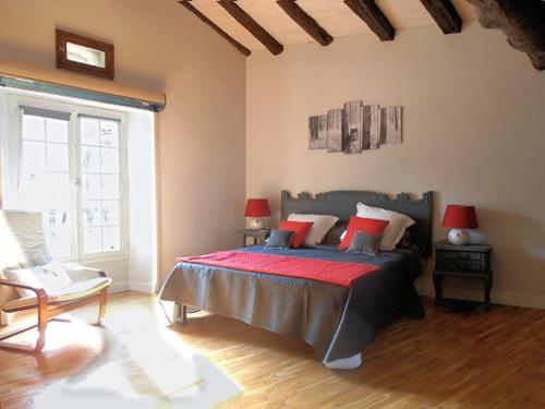 een slaapkamer met een bed en een groot raam bij la Fadette in Saint-Lizier