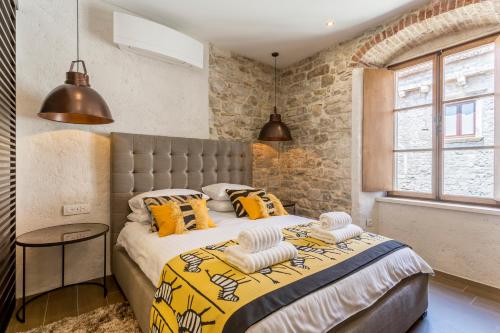 a bedroom with a large bed with yellow and orange pillows at byGRACE Apartment in Split