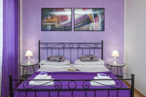 - une chambre violette avec un lit et 2 tables dans l'établissement B&B Villa Sophie, à Assise
