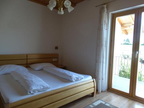 a bedroom with a bed and a large window at Fasslhof in Cornaiano