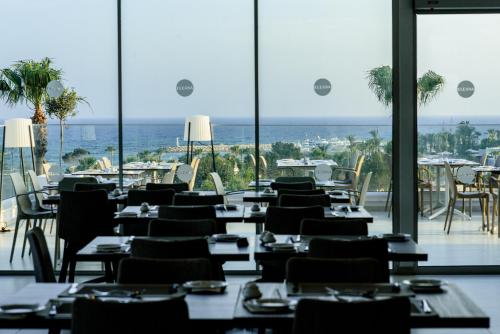 a restaurant with tables and chairs and a view of the ocean at Eleana Hotel in Ayia Napa