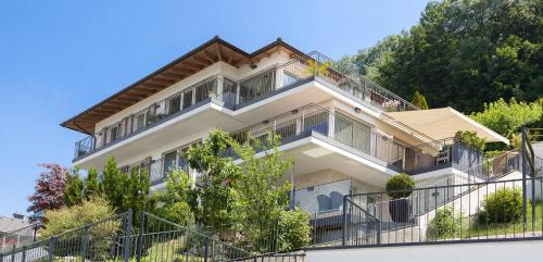 a large white house with balconies and trees at Apartments Villa Traunseeblick in Gmunden