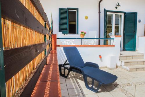 a blue chair sitting on a patio next to a building at Villa Maredona in Ascea