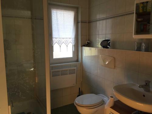 a bathroom with a toilet and a sink and a window at Ferienbungalow Klein Schweden in Ostseebad Koserow