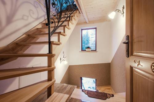 een houten trap in een huis met een raam bij Noclegi Bobrowski in Kościelisko