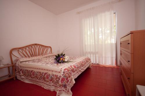 una camera da letto con un letto con una composizione floreale di Residence Diapason a Caorle