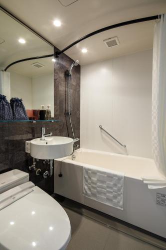 a bathroom with a sink and a tub and a toilet at Hotel Resol Kyoto Kawaramachi Sanjo in Kyoto