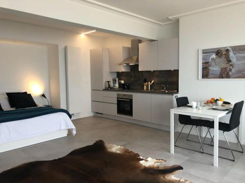 1 dormitorio con cama, mesa y cocina en Seaview Loft, en Ostende