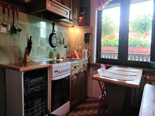 a kitchen with a stove and a sink and two windows at Apartament Kaszubski in Ostrzyce