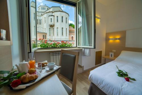 a hotel room with a bed and a tray of food at Hotel Delle Rose in Cascia