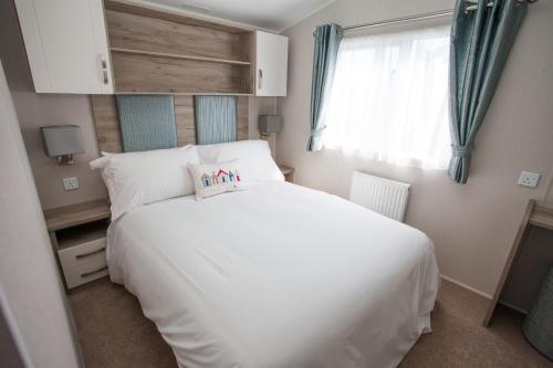 a bedroom with a white bed and a window at Little treamble holidays in Cubert