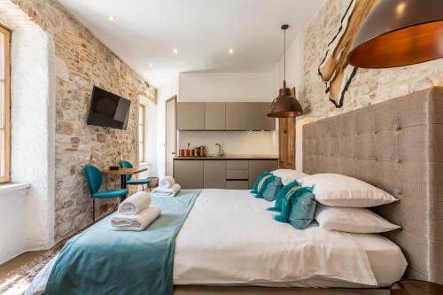 a bedroom with a large bed with blue and white pillows at byGRACE Apartment in Split