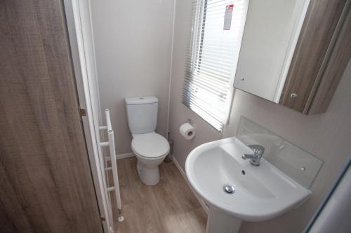 a bathroom with a white toilet and a sink at Little treamble holidays in Cubert