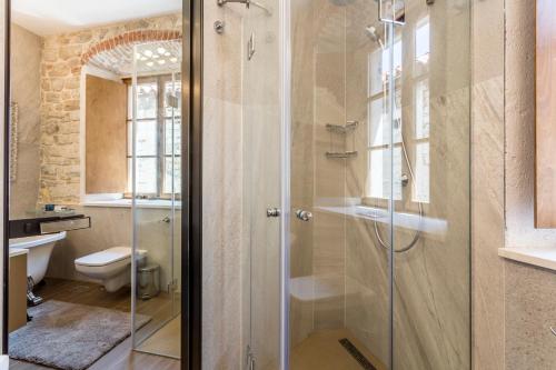 een badkamer met een glazen douche en een toilet bij byGRACE Apartment in Split
