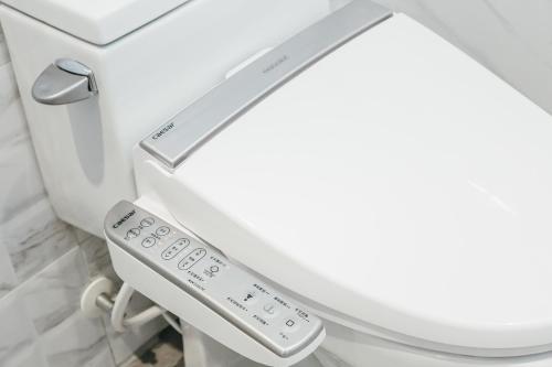 a toilet with a remote control on it at Muzik Hotel - Ximending Xining Branch in Taipei