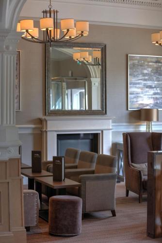 a living room with a fireplace and a mirror at Inverness Palace Hotel & Spa, WorldHotels Distinctive in Inverness