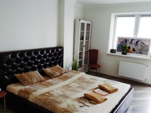 a bedroom with a large bed with a black headboard at Apartment on Morozova in Brest
