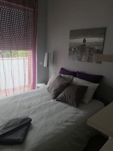a bedroom with a large bed with a window at Apartamentos El Cuco in Boó de Piélagos