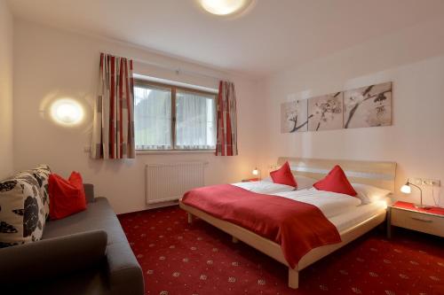 マイヤーホーフェンにあるFerienhaus Gredlerのベッドとソファ付きのホテルルーム