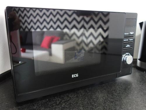 a microwave oven with a picture of a room at Apartmán s výhľadom na Tatry in Tatranska Strba