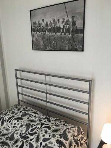 ein Schlafzimmer mit einem Bett mit einem Bild an der Wand in der Unterkunft Apartament Praga in Warschau