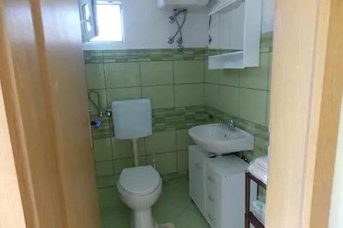 a bathroom with a toilet and a sink at Rocco apartments in Pag