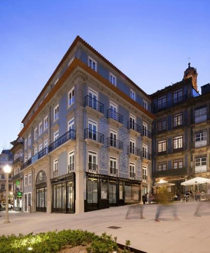 un grand bâtiment avec des gens qui marchent devant dans l'établissement Porto A.S. 1829 Hotel, à Porto