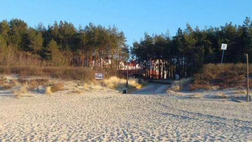 a dirt road with trees in the background at Continental Apartament przy plazy in Krynica Morska