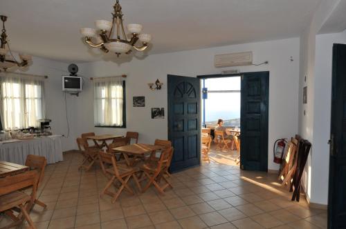 a dining room with a table and chairs and a chandelier at Aiolos Iraklia in Iraklia