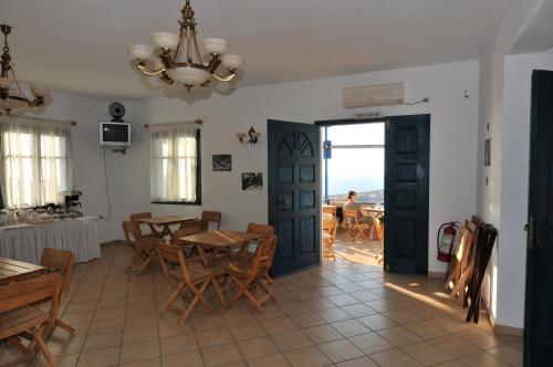 a dining room with a table and chairs and a chandelier at Aiolos Hotel in Irakleia