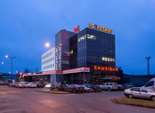 a building with cars parked in a parking lot at A comfortable room with balcony in Tallinn