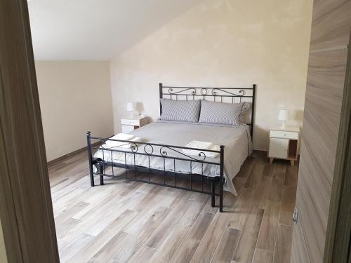 a bedroom with a bed and a wooden floor at memeapartments in Genova