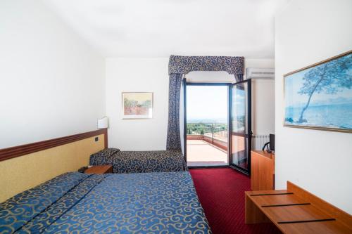 a hotel room with a bed and a large window at Hotel Italia & Lombardi in Montefiascone
