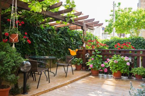 a patio with a table and chairs and flowers at Guest house Eos in Sozopol