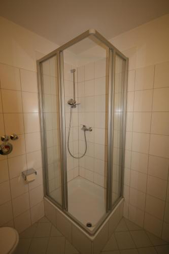 a shower with a glass enclosure in a bathroom at Appartements Domizil in Kaprun