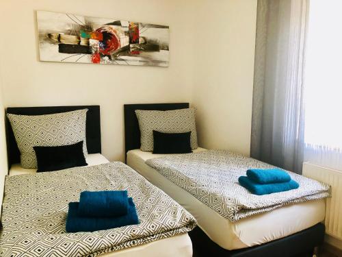a bedroom with two beds with blue pillows on them at KriDa Comfort Ferienwohnung in Garbsen