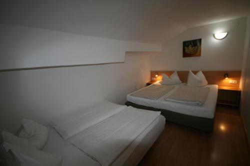 a hotel room with two beds in a room at Familienappartements Eder - Free entry to Tauern SPA Kaprun included in Kaprun