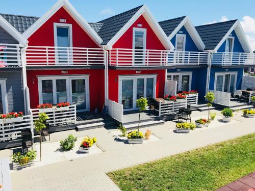 een rij huizen met rood en blauw bij Domki Morza Szum z basenem in Sarbinowo