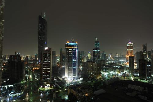 a city skyline at night with lit up buildings at Millennium Central Kuwait Downtown in Kuwait