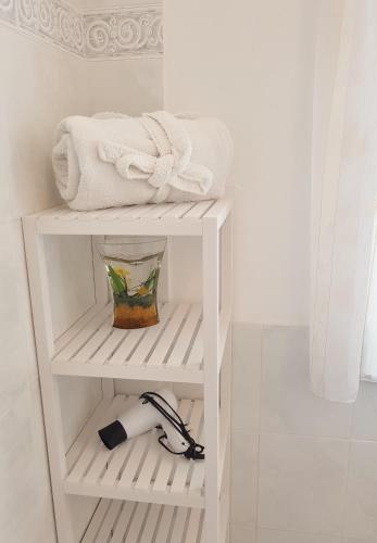 a white shelf with towels and a bowl on it at Casa Oliver in Lucca
