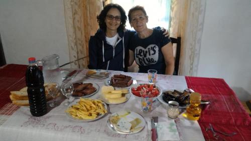 a man and a woman sitting at a table with food at Kulla e Sadri Lukes in Theth