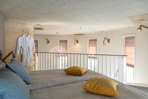 Un dormitorio con una cama con almohadas amarillas. en Watertorenhotel Nes, en Nes