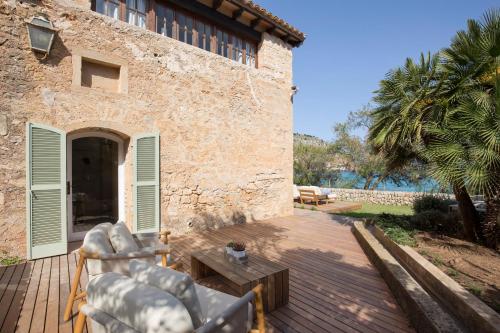 a patio with two chairs and a table next to a building at Can Simoneta - Adults Only in Canyamel