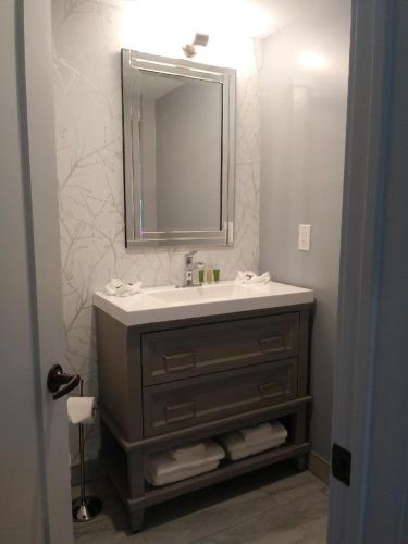 a bathroom with a sink and a mirror at Wasaga Riverdocks Hotel Suites in Wasaga Beach